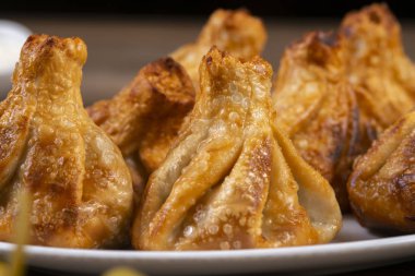 Beyaz bir tabakta kızarmış khinkali. Gürcü mutfağı..