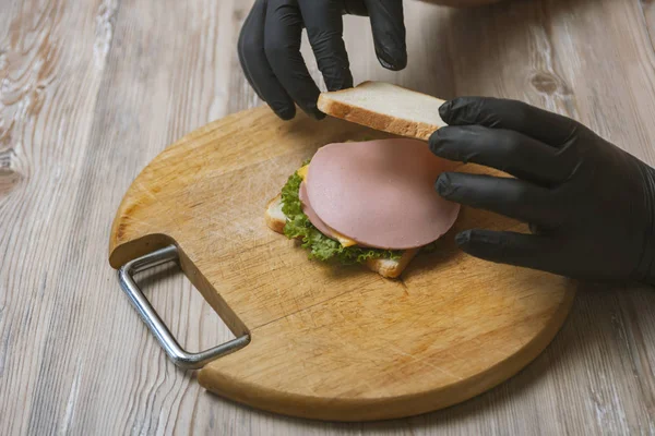 男人在桌子上准备三明治的特写镜头 — 图库照片