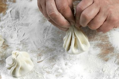 Aşçı ahşap masada khinkali yapıyor. İşlem hazırlığı Gürcistan yemeği. yiyecek konsepti.