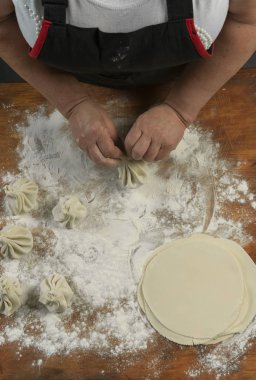Aşçı ahşap masada khinkali yapıyor. İşlem hazırlığı Gürcistan yemeği. yiyecek konsepti.