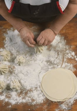 Aşçı ahşap masada khinkali yapıyor. İşlem hazırlığı Gürcistan yemeği. yiyecek konsepti.