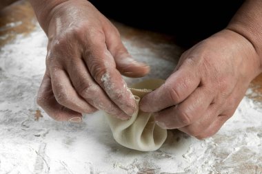Aşçı ahşap masada khinkali yapıyor. İşlem hazırlığı Gürcistan yemeği. yiyecek konsepti.