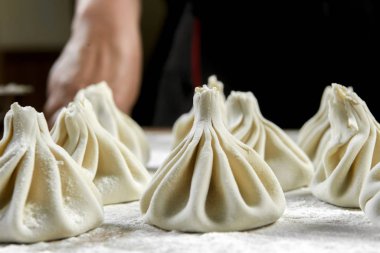 Aşçı ahşap masada khinkali yapıyor. İşlem hazırlığı Gürcistan yemeği. yiyecek konsepti.