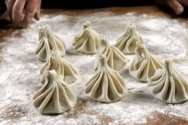 Aşçı ahşap masada khinkali yapıyor. İşlem hazırlığı Gürcistan yemeği. yiyecek konsepti.