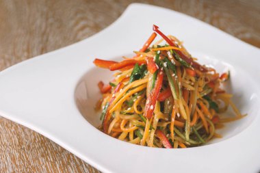 Vejetaryen biber ve ahşap masa üzerinde havuç salatası