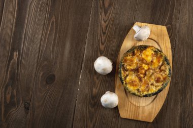 Tahta masa üzerinde peynir hamuruyla pişirilmiş mantarlar.