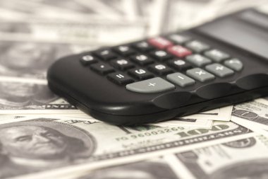 Birkaç dolar ve masa üzerinde bir hesap makinesi, finans ve tasarruf. İş konsepti