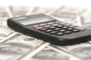 Birkaç dolar ve masa üzerinde bir hesap makinesi, finans ve tasarruf. İş konsepti