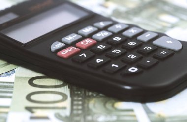 Birkaç Euro ve masada bir hesap makinesi, finans ve tasarruf. İş konsepti