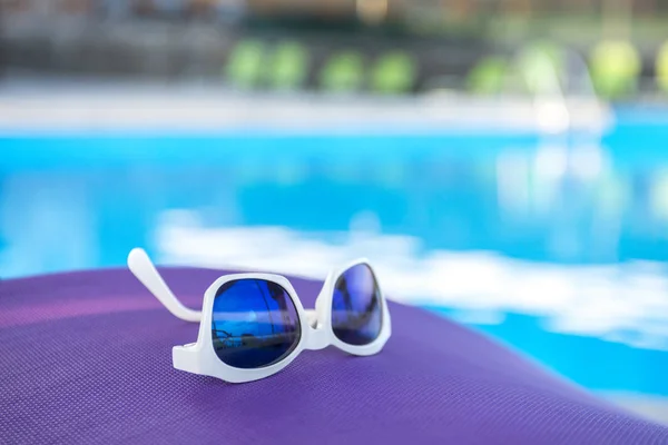 Óculos de sol nos salões de sol na piscina — Fotografia de Stock