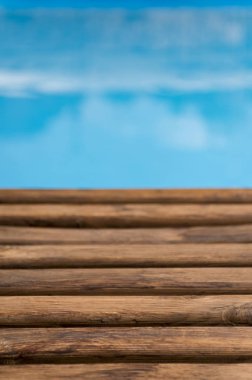 Ufukta ahşap zemin ile bulanık deniz arka planı; güneşli bir tatil, gökyüzü sörf yaz bulutları dokunarak cennet zihin manzaralı açık hava tatili.