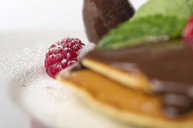 çikolata ve beyaz arka planda ahududu ile gözleme