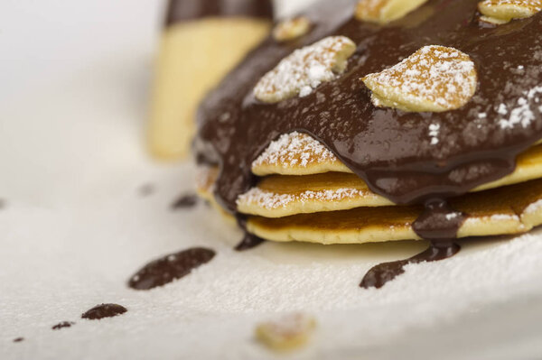 блины с шоколадом и малиной на белом фоне
