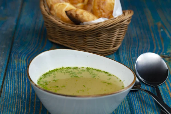 Kippenbouillon Witte Kom Gebakken Taarten Een Mandje Blauw Houten Bureau — Stockfoto