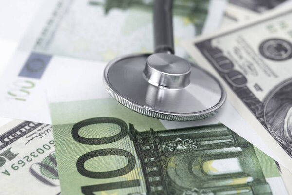 medical stethoscope on dollars and euro banknotes.coronavirus