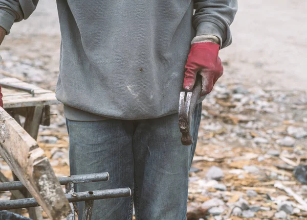 a working carpenter in dirty clothes works at a construction site