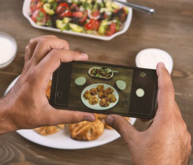Akıllı telefondan yemek fotoğrafçılığı. Mans elleri geleneksel doğu yemeklerini telefonla çekiyor. Öğle ya da akşam yemeği. Khinkali. Sosyal medya ve blog için. Üst görünüm cep telefonu.