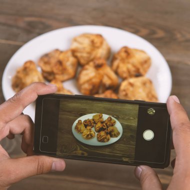Yemeklerin akıllı telefon fotoğrafı. İnsan elleri geleneksel doğu yemeklerini telefonla çekiyor. Öğle ya da akşam yemeği. Khinkali. Sosyal medya ve blog için. Üst görünüm cep telefonu.