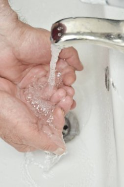 yaşlı adam banyoda ellerini yıkıyor