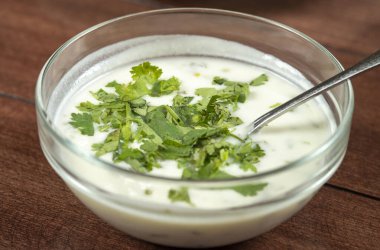Yoğurt çorbası, ahşap masadaki bir tabakta otlar. Spa.