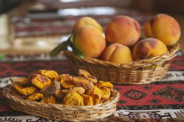 Kurumuş meyve ve taze şeftali arkaplanda sepetin içinde yapraklarla.