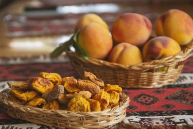Kurumuş meyve ve taze şeftali arkaplanda sepetin içinde yapraklarla.