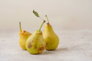 üç sarı sonbahar armudu beyaz ahşap bir zemin