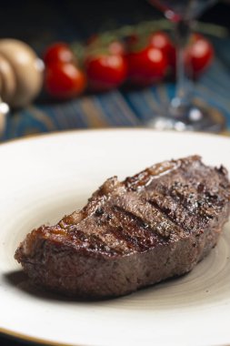 Izgara biftek, kiraz domatesleri ahşap masada tuz ve biber..