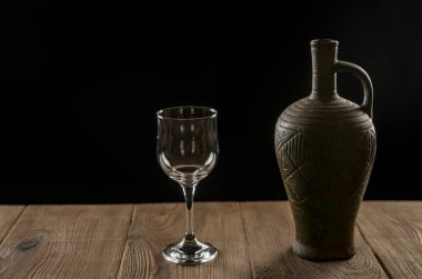 Bir sürahi şarap ve ahşap bir masada bir bardak