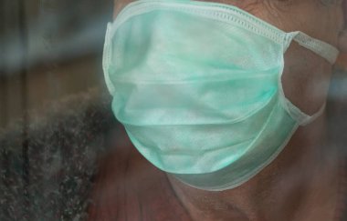 Pencerede maske takan yaşlı bir adam. - Yakın çekim. Karantina