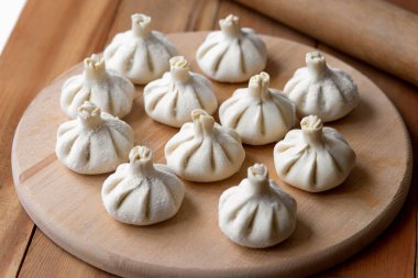 Ahşap masada çiğ donmuş khinkali. İşlem hazırlığı Gürcistan yemeği. yiyecek konsepti.