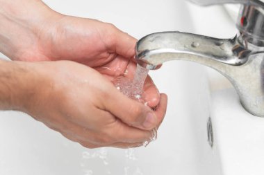 Erkek ellerini banyoda yıkar. Corona virüsü enfeksiyonuna karşı en iyi korunma. Corona virüsü sık sık ellerini temizleyerek pandemik koruma sağlar..