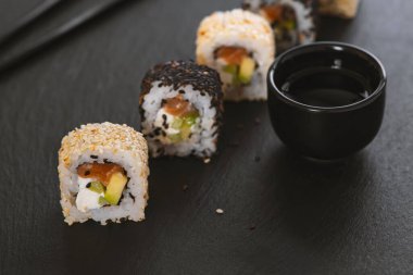 Pilavlı suşi, salatalık, avokado, somon, susam. Suşi menüsü. Japon yemeği..