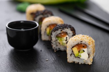Pilavlı suşi, salatalık, avokado, somon, susam. Suşi menüsü. Japon yemeği..