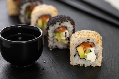 Pilavlı suşi, salatalık, avokado, somon, susam. Suşi menüsü. Japon yemeği..