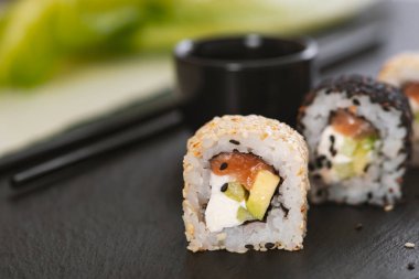 Pilavlı suşi, salatalık, avokado, somon, susam. Suşi menüsü. Japon yemeği..