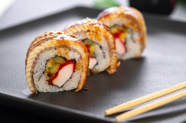 Pilavlı suşi, yengeç, salatalık, avokado, tobiko, yılan balığı. Suşi menüsü. Japon yemeği..