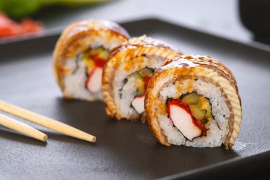 Pilavlı suşi, yengeç, salatalık, avokado, tobiko, yılan balığı. Suşi menüsü. Japon yemeği..