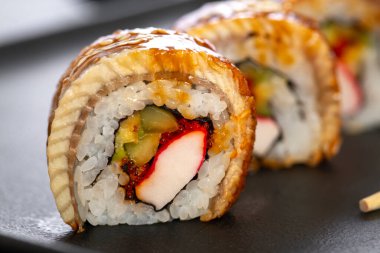 Pilavlı suşi, yengeç, salatalık, avokado, tobiko, yılan balığı. Suşi menüsü. Japon yemeği..