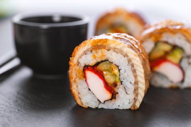 Pilavlı suşi, yengeç, salatalık, avokado, tobiko, yılan balığı. Suşi menüsü. Japon yemeği..