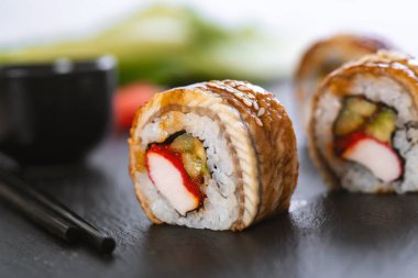 Pilavlı suşi, yengeç, salatalık, avokado, tobiko, yılan balığı. Suşi menüsü. Japon yemeği..