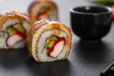 Pilavlı suşi, yengeç, salatalık, avokado, tobiko, yılan balığı. Suşi menüsü. Japon yemeği..