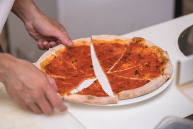 Şef mutfakta pizza yapıyor.