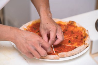 Şef mutfakta pizza yapıyor.