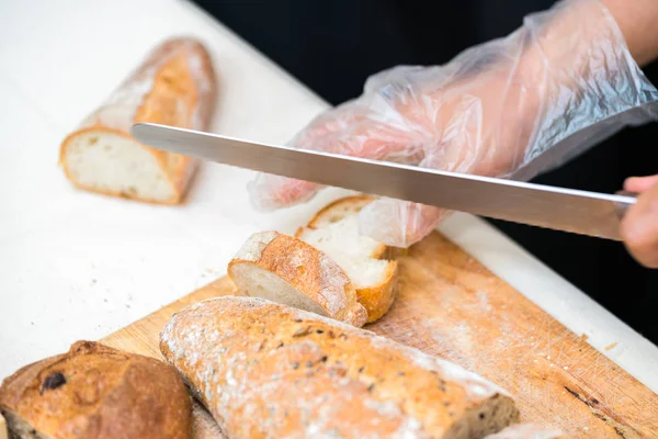 Chef rebanando pan en la cocina — Foto de Stock