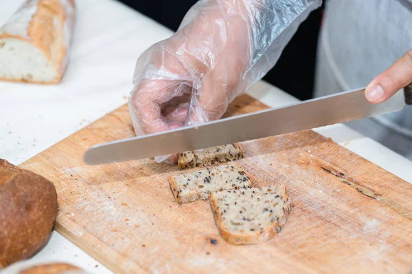 Chef rebanando pan en la cocina — Foto de Stock