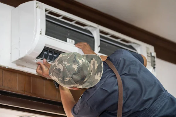 Technician is fixing air conditioner — Stock Photo, Image