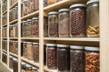 Raflarda renkli baharatlar ile cam şişe