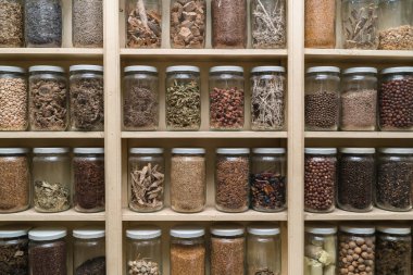 Raflarda renkli baharatlar ile cam şişe