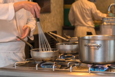 Şef mutfakta yemek pişiriyor.